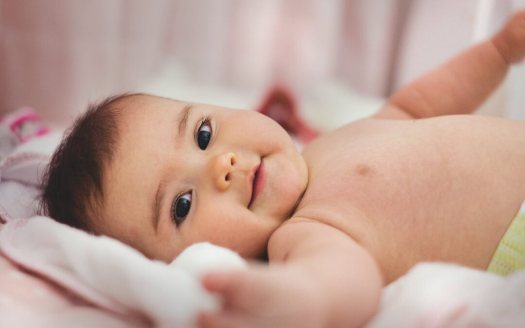 baby lying on pink bed